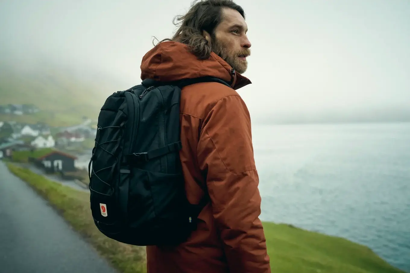 male hiker looking out over a large lake