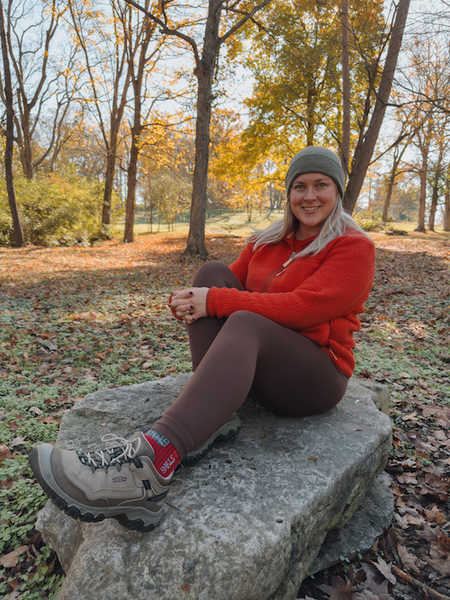 Influencer sitting in forest, wearing KEEN hiking boots