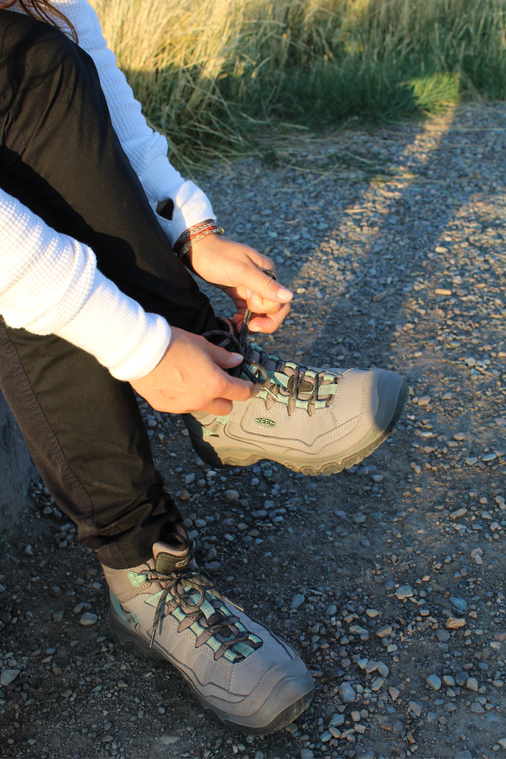 close up of KEEN hiking boots on man sitting down in forest on a rock