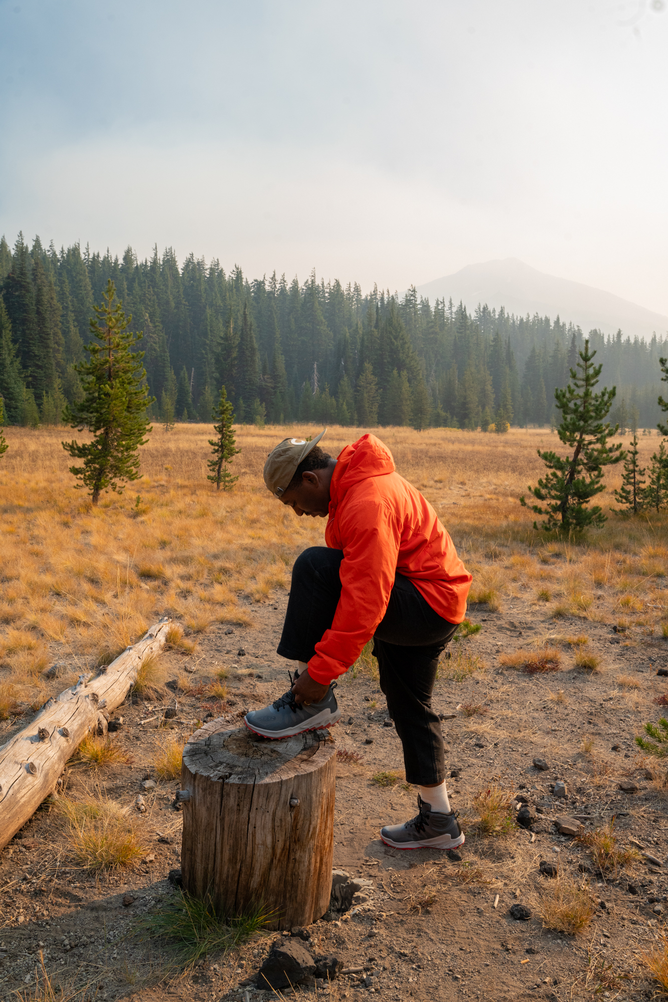 close up of KEEN hiking boots on man sitting down in forest on a rock